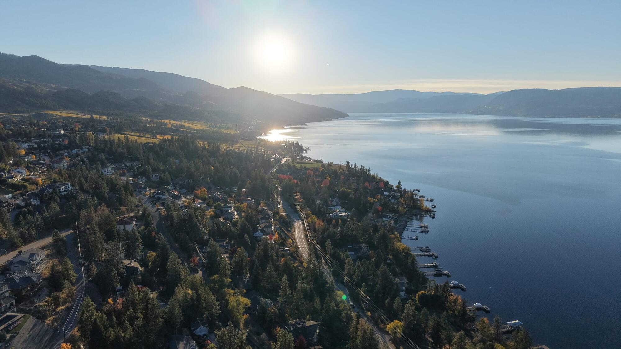 Aerial view south along Okanagan Lake at sunset, with docks along the shoreline